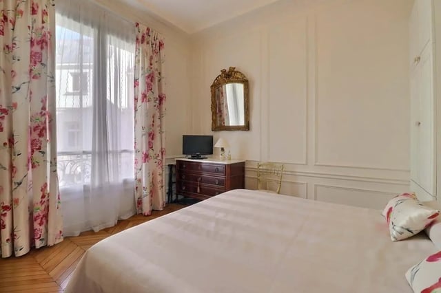 Bed chest TV mirror chair bedroom at Apartment in Rue Villaret de Joyeuse, 75017 Paris, France in Paris Student Accommodation