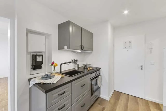Grey cabinets sink faucet and oven kitchen at Zimmer in der Hohenzollerndamm 58 in Berlin Student Accommodation