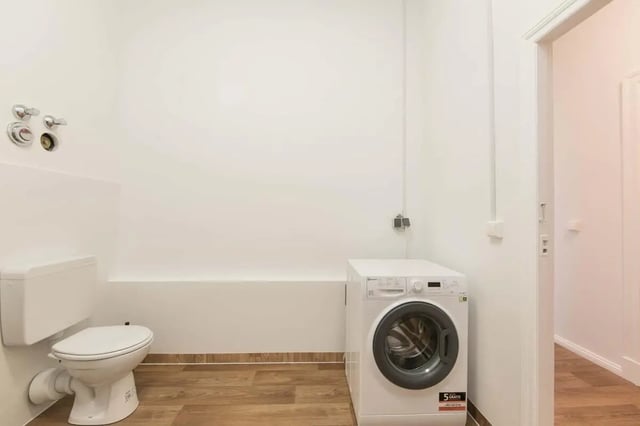 Toilet and washing machine in a small room at Hohenzollerndamm 53.6 in Berlin Student Accommodation