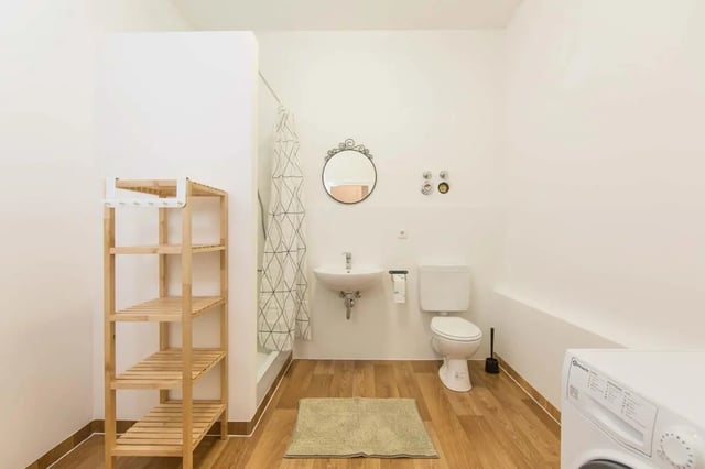 Wooden shelves sink toilet shower curtain washing machine bathroom at Hohenzollerndamm 53.6 in Berlin Student Accommodation