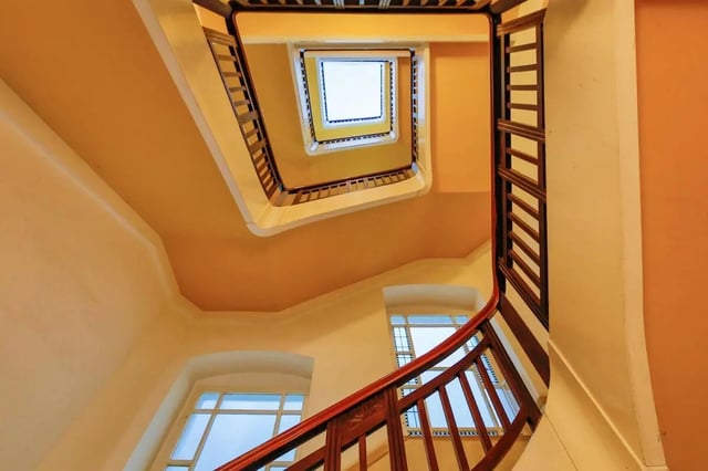 Spiral staircase with wooden railing and windows staircase at Hohenzollerndamm 53.6 in Berlin Student Accommodation