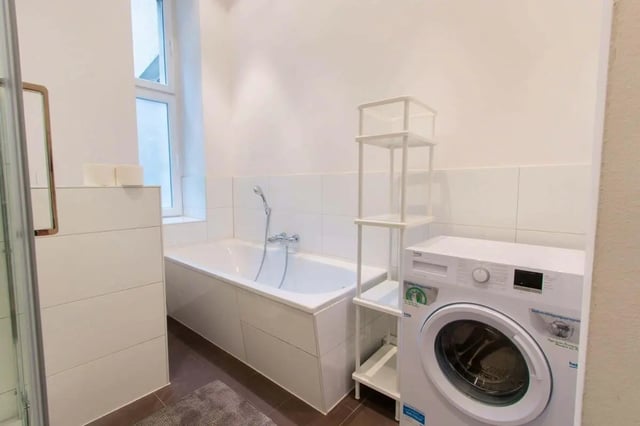 White bathtub washing machine and storage shelves bathroom at Room in Detmolder Str., 10713 Berlin, Germany in Berlin Student Accommodation