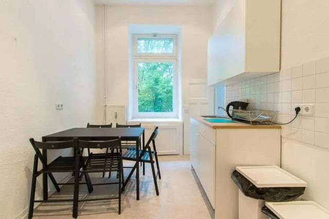 Table chairs window kettle sink and trash bins kitchen at Room in Detmolder Str., 10713 Berlin, Germany in Berlin Student Accommodation