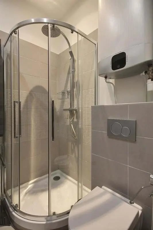 Glass shower enclosure toilet and water heater bathroom at Apartment 1 bedroom 41m² in Paris Student Accommodation