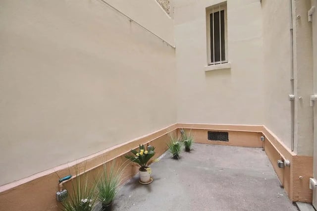 Courtyard with potted plants and a barred window exterior at Apartment 1 bedroom 41m² in Paris Student Accommodation