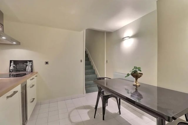 Table chairs stairs and kitchen area at Apartment in Rue Saint-Honoré, 75001 Paris, France in Paris Student Accommodation