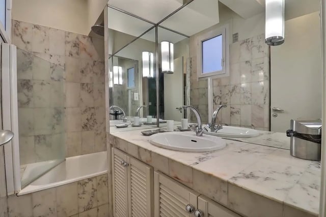 Marble tiled bathroom with white basin and tub Bathroom at Apartment in Rue Saint-Honoré, 75001 Paris, France in Paris Student Accommodation