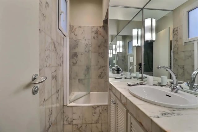 Marble tiled bathroom with bathtub and double sinks bathroom at Apartment in Rue Saint-Honoré, 75001 Paris, France in Paris Student Accommodation
