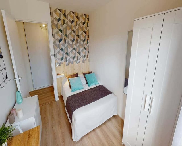 Bed with blue pillows and closet bedroom at Chambre dans le Place de la Montagne du Goulet in Paris Student Accommodation