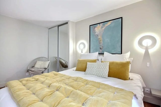 Tufted yellow quilt bed accent pillows large art bedroom at Apartment 1 bedroom 60m² in Paris Student Accommodation