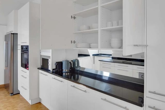 White cabinets with open shelves showing dishes and appliances kitchen at Rue de Bretagne in Paris Student Accommodation