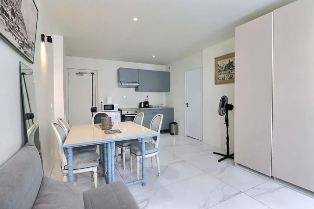 Dining area and kitchen with grey cabinets and table. at Apartment in Rue Sedaine, Paris for 37 m² with 1 bedroom in Paris Student Accommodation