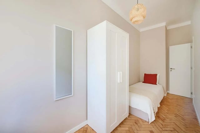 Wardrobe mirror bed with red pillow bedroom at Bedroom in a 10-Bedroom Apartment in Avenida Estados Unidos da América, Lisbon - Room 1 in Lisbon Student Accommodation