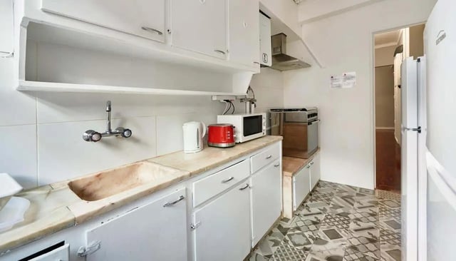 White cabinets sink toaster kettle microwave stove kitchen at Casa Abel II – Room 5 in Lisbon Student Accommodation