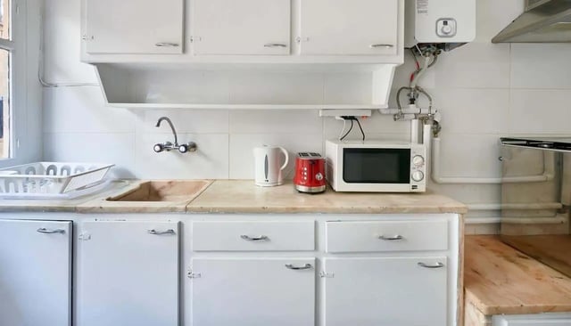 Sink kettle toaster microwave and cabinets kitchen at Casa Abel II – Room 5 in Lisbon Student Accommodation
