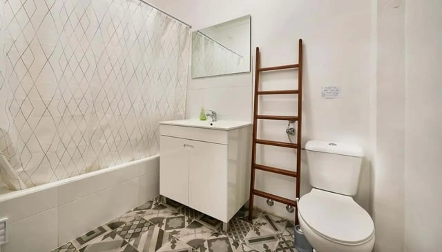 Sink cabinet toilet ladder shower curtain bathroom at Casa Abel II – Room 5 in Lisbon Student Accommodation