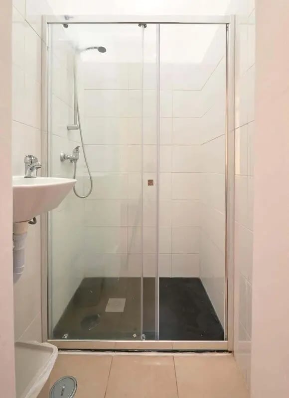 Shower with sink and tiled walls bathroom at Casa Elias III – Room 11 in Lisbon Student Accommodation