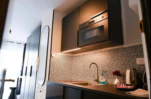 Modern black cabinets microwave sink and kettle kitchen at Splendide grand studio parking Canal Saint Martin (Paris) in Paris Student Accommodation