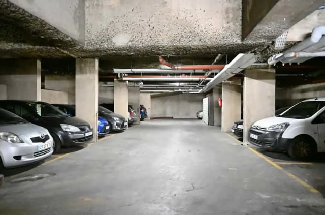 Cars parked in a concrete underground parking lot. at Splendide grand studio parking Canal Saint Martin (Paris) in Paris Student Accommodation