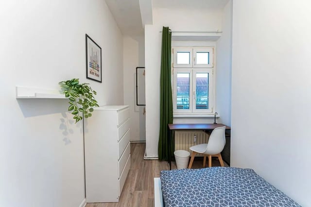 White dresser and bed with plant bedroom at Sterndamm 75.2 75.3 in Berlin Student Accommodation