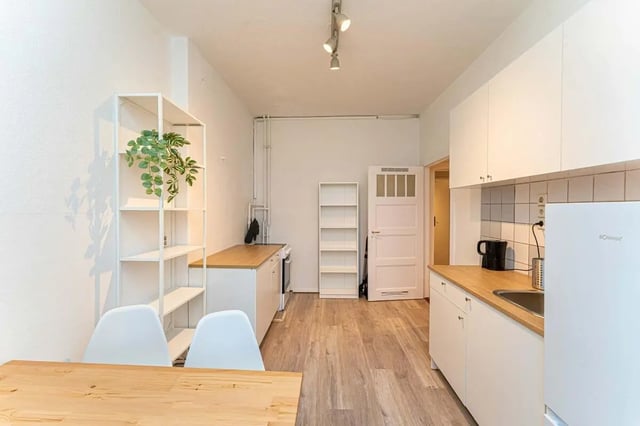 White shelves table chairs and kitchen area kitchen at Sterndamm 75.2 75.3 in Berlin Student Accommodation