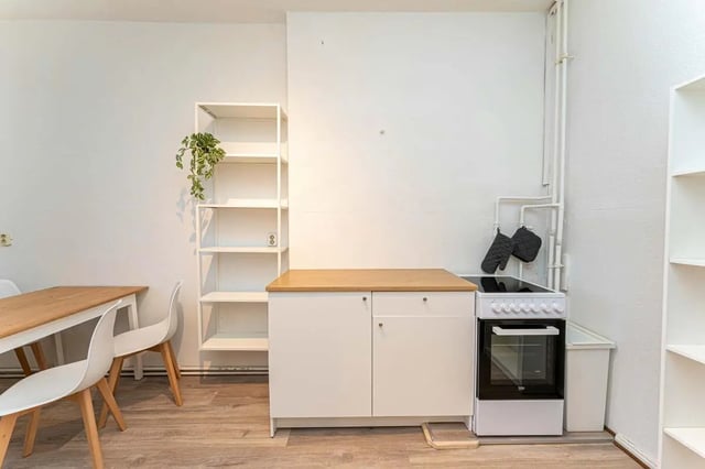 White cabinets oven shelving dining table chairs kitchen at Sterndamm 75.2 75.3 in Berlin Student Accommodation