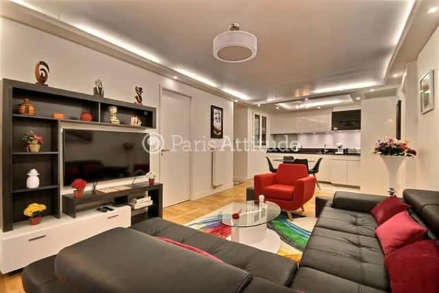 Living room with black sofa red armchair kitchen living room at Apartment in Rue de Clichy, 75009 Paris, France in Paris Student Accommodation