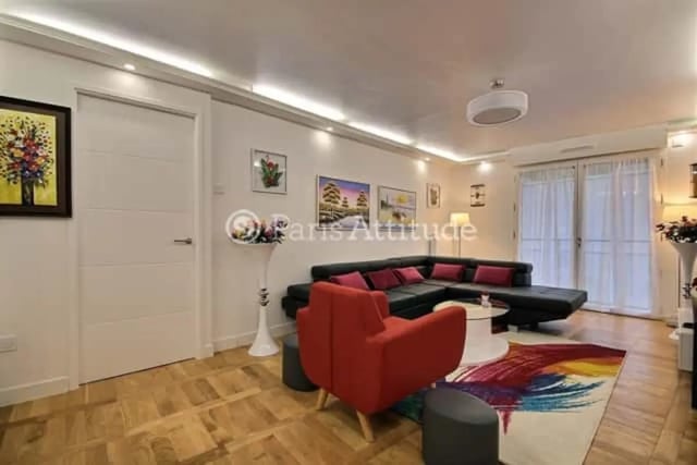 L-shaped black sofa red chairs modern living room living room at Apartment in Rue de Clichy, 75009 Paris, France in Paris Student Accommodation