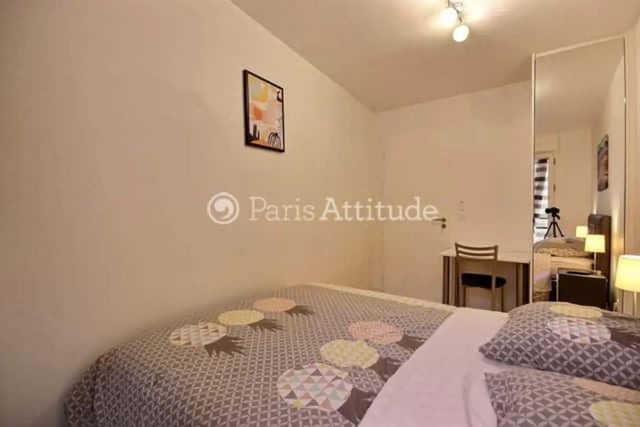 Bed with patterned duvet and desk study area at Apartment in Rue de Clichy, 75009 Paris, France in Paris Student Accommodation