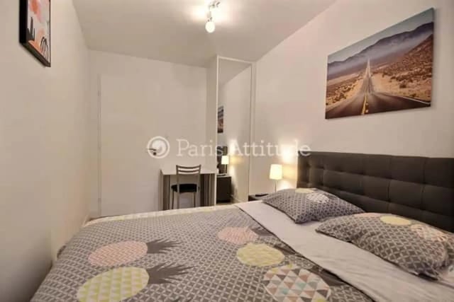 Bed with patterned duvet and desk study area bedroom at Apartment in Rue de Clichy, 75009 Paris, France in Paris Student Accommodation
