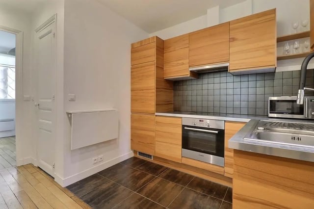 Wood cabinets oven sink and microwave kitchen at Apartment in Rue Etienne Jodelle, 75018 Paris, France in Paris Student Accommodation