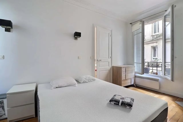 Bed with nightstand dresser open window bedroom at Apartment in Rue Etienne Jodelle, 75018 Paris, France in Paris Student Accommodation