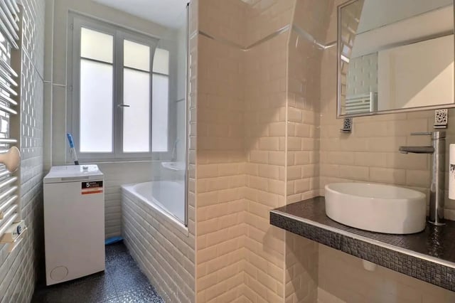 Washing machine sink bathtub with shower screen bathroom at Apartment in Rue Etienne Jodelle, 75018 Paris, France in Paris Student Accommodation