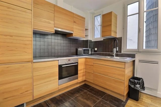 Wood cabinets oven sink microwave kitchen at Apartment in Rue Etienne Jodelle, 75018 Paris, France in Paris Student Accommodation