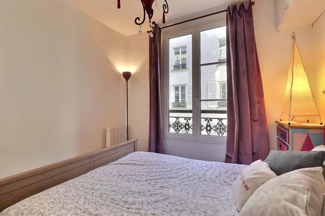 Bed with patterned duvet curtains radiator bedroom at Apartment 2 bedrooms 63m² in Paris Student Accommodation