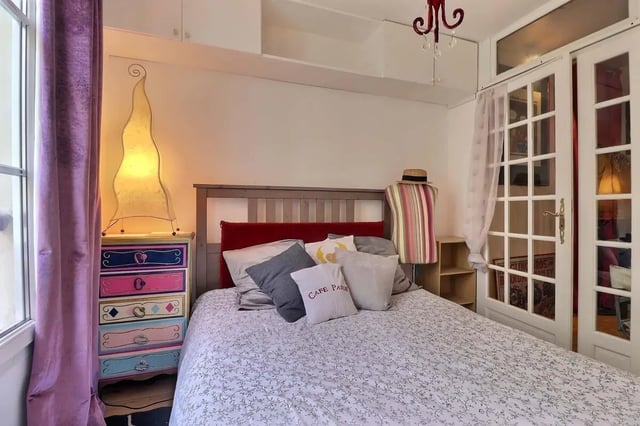 Bed with patterned duvet colorful dresser bedside lamp bedroom at Apartment 2 bedrooms 63m² in Paris Student Accommodation