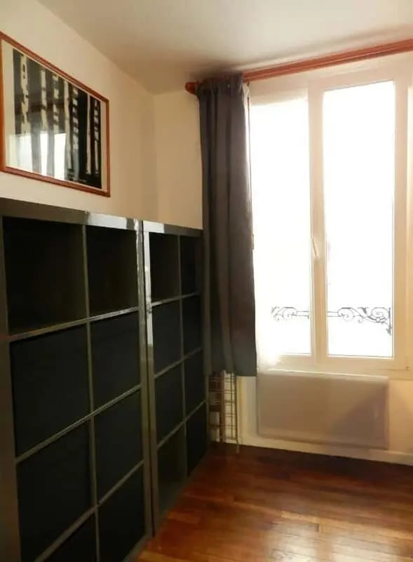 Two tall dark bookshelves near window and painting interior photograph at Apartment 1 bedroom 28m² in Paris Student Accommodation