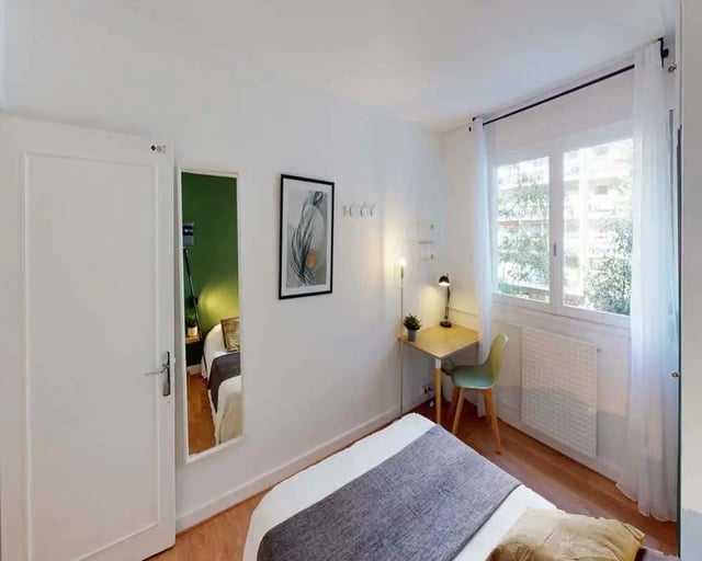 Bed desk chair artwork and mirror bedroom at Chambre dans le rue des morillons in Paris Student Accommodation
