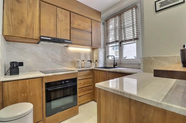 Wooden cabinets built-in oven toaster kettle kitchen at Apartment Studio 38m² in Paris Student Accommodation