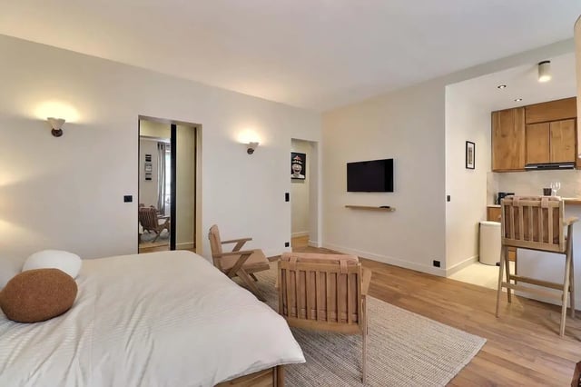 Bed two chairs television kitchen student accommodation living room at Apartment Studio 38m² in Paris Student Accommodation