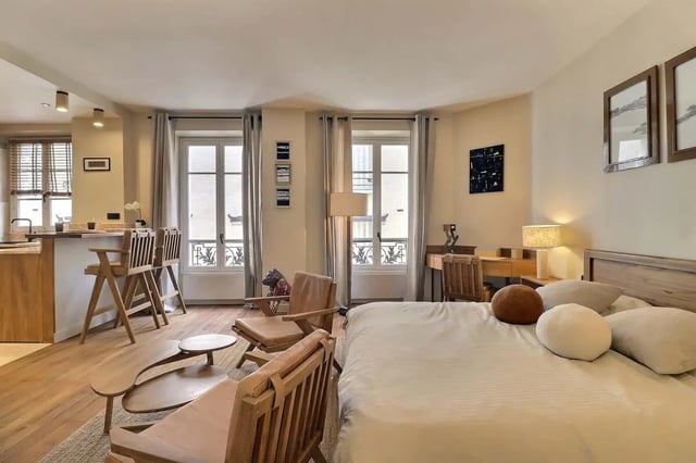 Bed desk chairs kitchen area and windows living room at Apartment Studio 38m² in Paris Student Accommodation