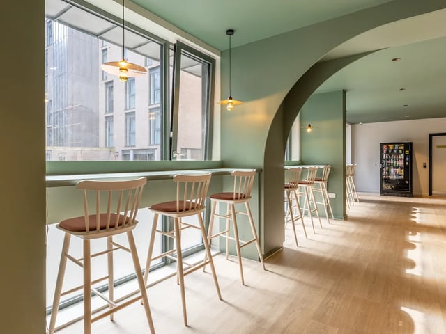 Bar stools by window with vending machine Common area at Dunaskin Mill in Glasgow Student Accommodation