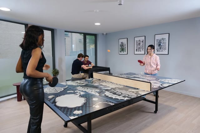 Ping pong table and players playing living room at Dunaskin Mill in Glasgow Student Accommodation