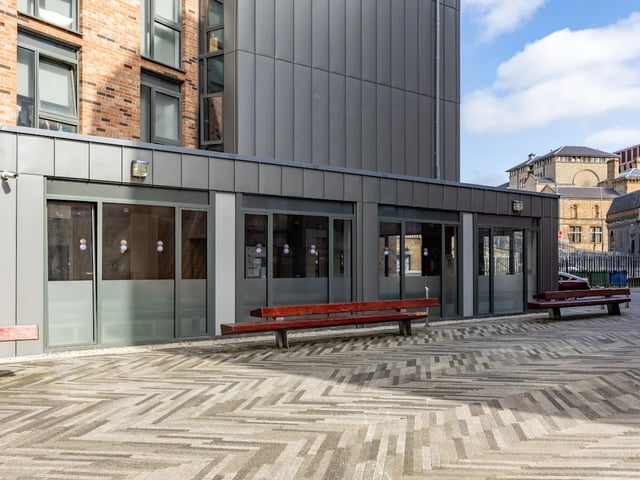 Wooden benches on patterned pavement exterior at Dunaskin Mill in Glasgow Student Accommodation
