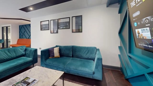 Two teal sofas marble table and TV living room at The Residence in Coventry Student Accommodation