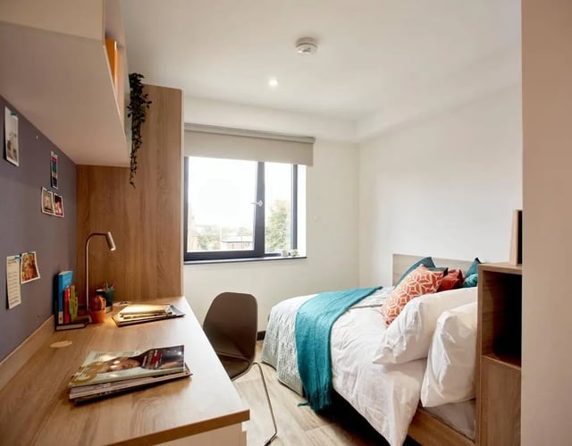 Desk with books chair bed with pillows bedroom at Eden Square in Coventry Student Accommodation