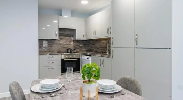 Dining table chairs plant white plates kitchen at Urban Student Village in Coventry Student Accommodation