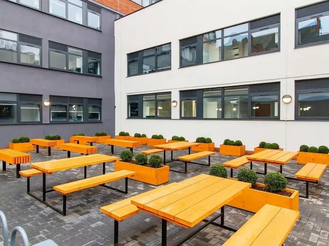 Orange picnic tables with benches outdoor courtyard area at Urban Student Village in Coventry Student Accommodation