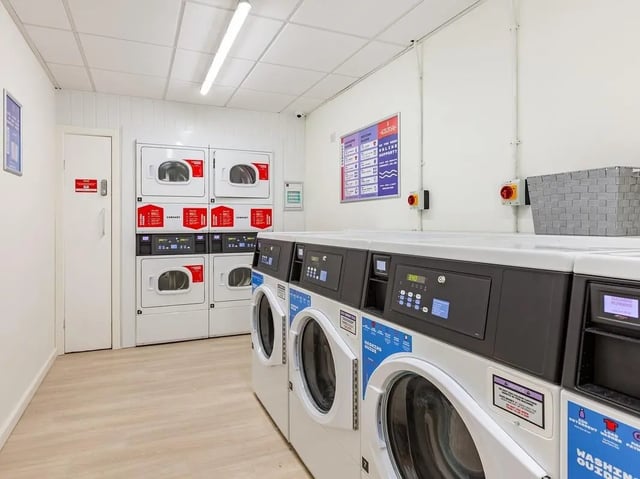 Washing machines and dryers lined up laundry room at Straits Meadow in Edinburgh Student Accommodation