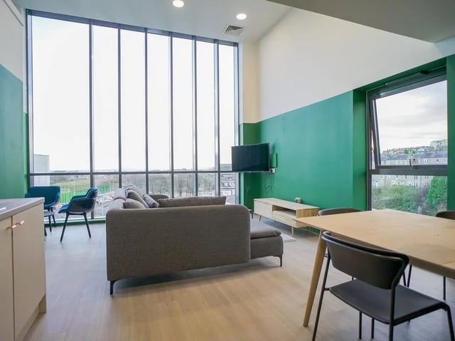 Sofa tv table chairs and large windows living room at Straits Meadow in Edinburgh Student Accommodation